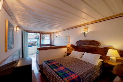 ein Schlafzimmer mit einem Bett in einem Zimmer mit einem Fenster in der Unterkunft Casa Figueira da Foz in Ouro Preto