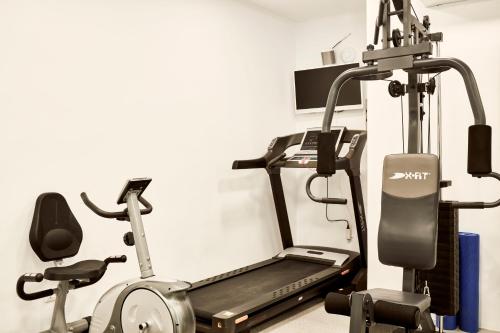 a gym with a treadmill and two exercise bikes at Mykonos No5 Luxury Suites & Villas in Ornos