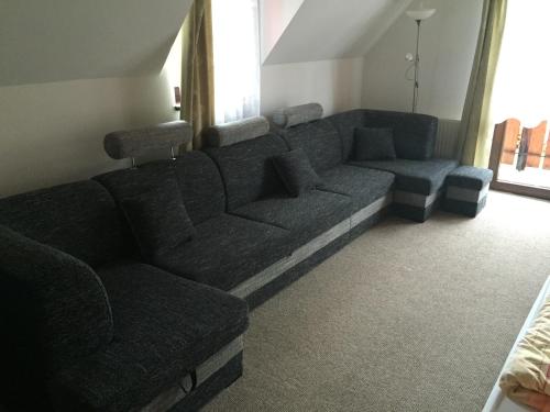 a large couch in a living room with a window at Penzion Slovakia in Ždiar