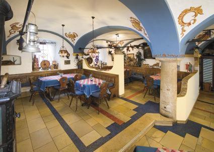 a restaurant with tables and chairs in a room at Hotel-Gasthof Zur Post in Velburg