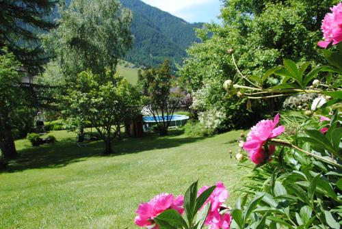 a garden with pink flowers in the grass at AppartChalet LA RONDULA - 100m from Seceda in Ortisei