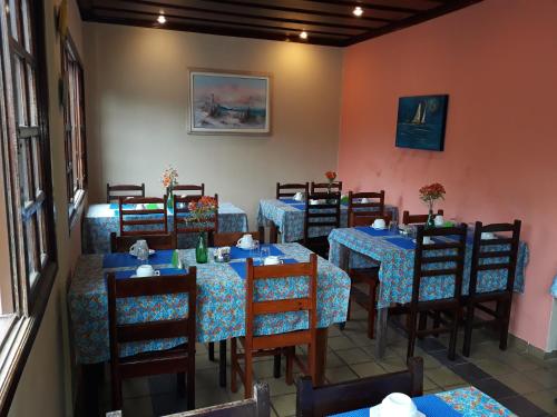 a dining room with blue tables and chairs at Enseada Hotel in Ubatuba