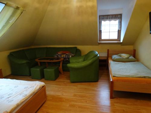 カルパチにあるDworek Karpaczのリビングルーム(ソファ、ベッド付)