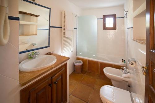 a bathroom with a sink and a toilet and a tub at Hotel Rural Can Pujolet in Santa Agnès de Corona