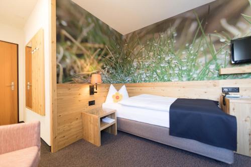 a hotel room with a bed and a tv at Hotel Garni Chesa Mulin in Pontresina