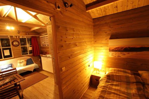 a room with a bed in a wooden wall at The Beach-house nr.98 in Molkwerum