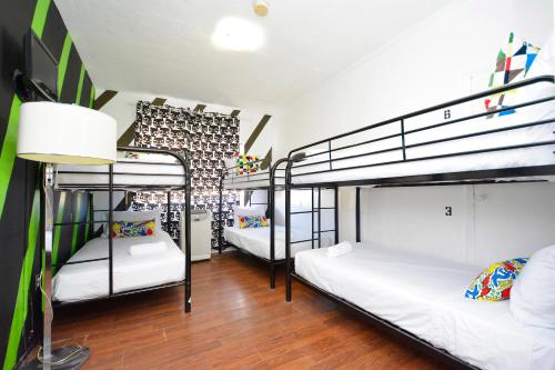 a room with three bunk beds in a room at South Beach Rooms and Hostel in Miami Beach