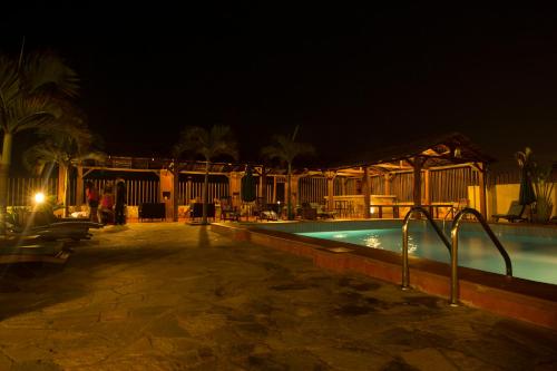 a swimming pool at night with a resort at The Palms at Prampram in Prampram