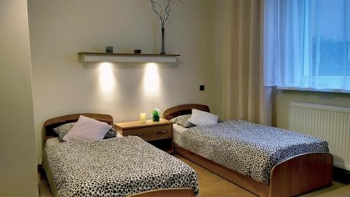 トルンにあるPod Jarzębinąのベッド2台、テーブル、窓が備わる客室です。