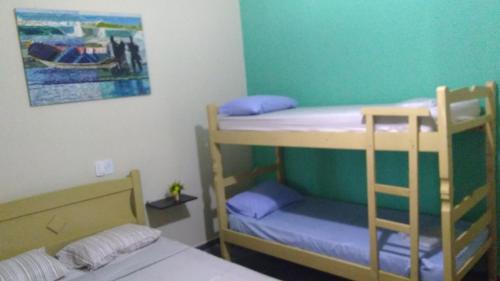 a room with two bunk beds and a bed at Pousada Jorai e Camping in Bertioga