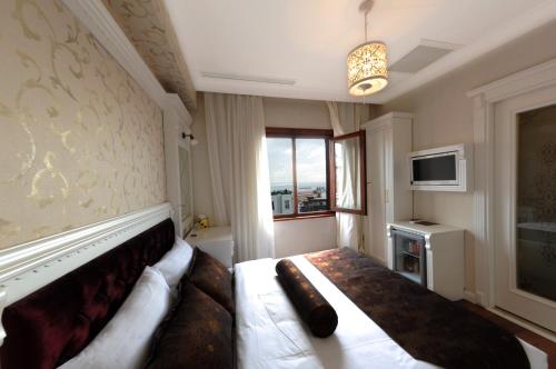イスタンブールにあるホテル コロシアムの大型ベッド1台、窓が備わるホテルルームです。