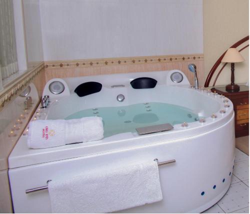 a bath tub in a bathroom with a towel at Hotel Oro Inn in Lima