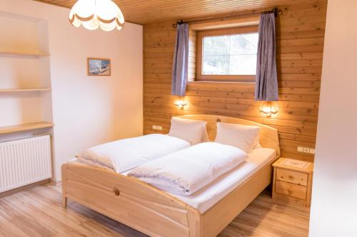 a bed in a room with a window at Landhaus Alpenrose in Mayrhofen