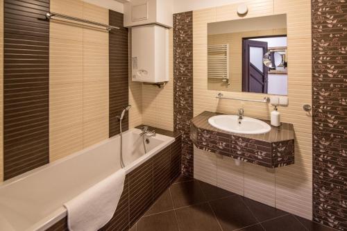 a bathroom with a sink and a bath tub and a mirror at Bed4You in Zielona Góra