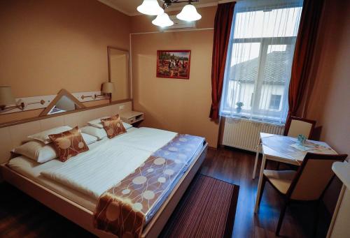 A bed or beds in a room at Gőzmalom Étterem és Panzió