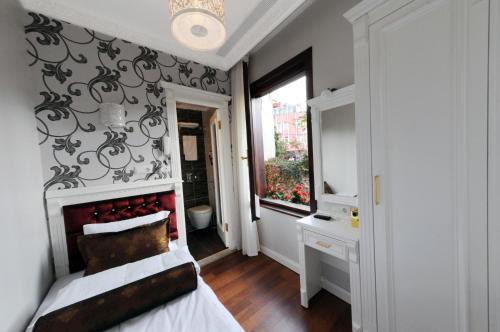 una camera da letto con un letto con testiera rossa e una finestra di Hotel Coliseum a Istanbul