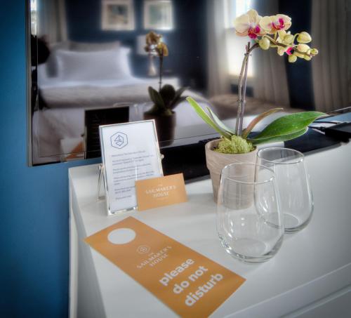 a table in a hotel room with glasses and a sign at The Sailmaker's House in Portsmouth