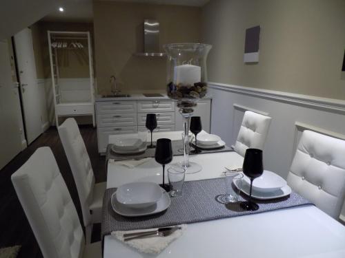 ein Esszimmer mit einem weißen Tisch und Stühlen in der Unterkunft Hs4U The Romantic Luxury apartment in Prato