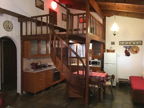 a kitchen with a wooden spiral staircase in a room at Villa Kazantzakis in Archanes