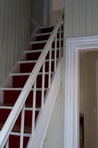 a staircase in a house with white rails at Steinhúsið in Hólmavík