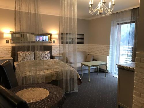 a room with a bed and a table and a chair at Kwaterka in Brenna