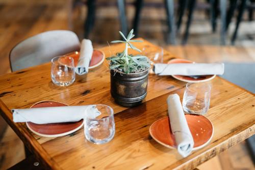 a wooden table with plates and glasses and a plant on it at Park City Peaks in Park City