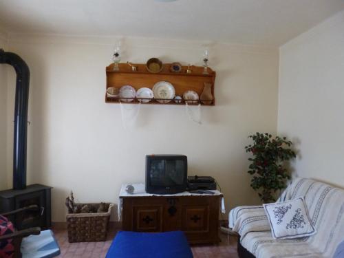 a living room with a couch and a tv at Casa de Santana in Arneiro