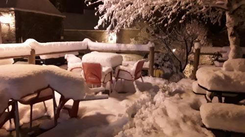 a yard covered in snow with chairs and a fence at Hotelet de Betlan in Betlán
