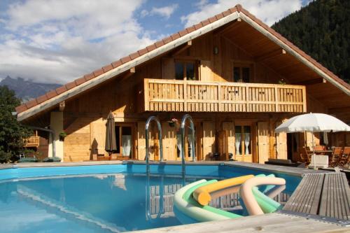 un complexe avec une piscine et une maison dans l'établissement Appartement Andromède 25 minutes de Chamonix, à Saint-Gervais-les-Bains