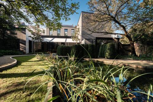 a house with a pond in front of a building at Cabosse, Boutique Palace & Spa in Antwerp