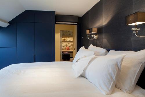 a bedroom with a large bed with white pillows at Cabosse, Boutique Palace & Spa in Antwerp