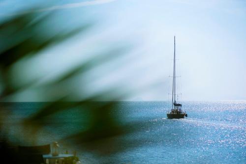 a sailboat in the middle of the ocean at Vithos Seaside Aparthotel in Astypalaia Town