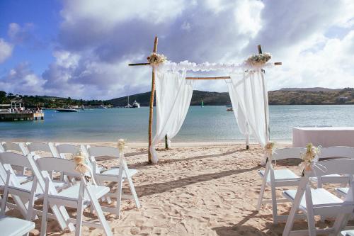 a wedding altar on a beach with chairs at St. James's Club Resort - All Inclusive in English Harbour Town