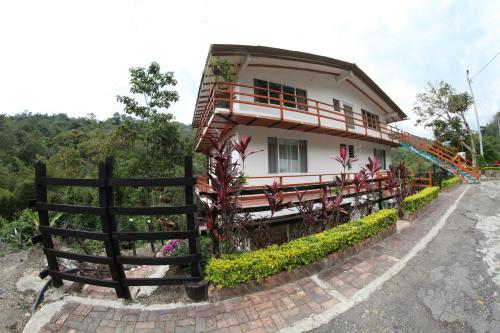 a house with a fence in front of it at HOTEL LA SELVA Reserva in La Vega