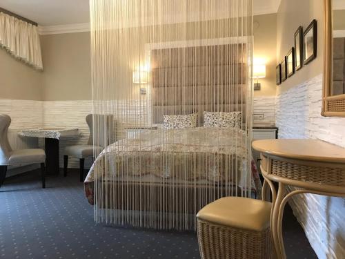 a hotel room with a bed and a table and chairs at Kwaterka in Brenna