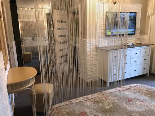 a bedroom with a bed and a table and a tv at Kwaterka in Brenna
