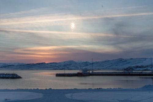 a view of a body of water with snow covered mountains at Steinhúsið in Hólmavík
