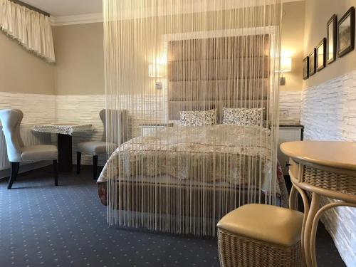 a hotel room with a bed and a table and chairs at Kwaterka in Brenna