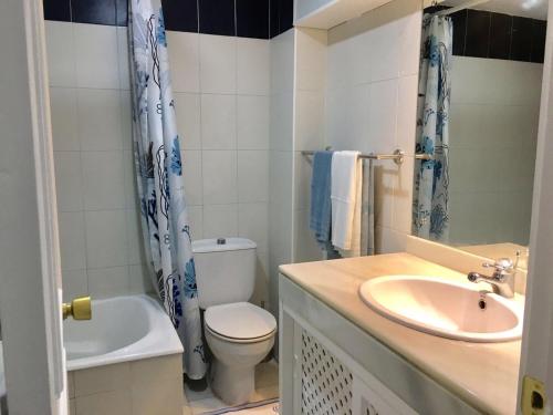 a bathroom with a sink and a toilet and a tub at Puerto marina in Benalmádena