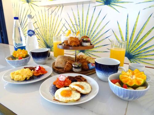 a table topped with plates of breakfast foods and drinks at Apolline in Fort-de-France