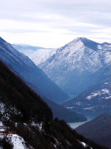 a view of a snowy mountain range with a lake at Planinska Koliba Exclusive in Sekulić 