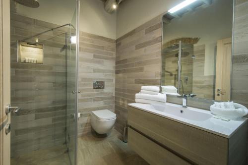 a bathroom with a toilet and a sink and a shower at Borgo Argiano in Castelnuovo Berardenga