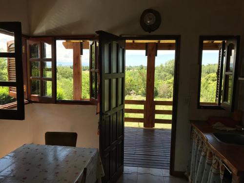Habitación con puerta que da a un porche con ventanas. en cabaña La Retama en Villa Yacanto