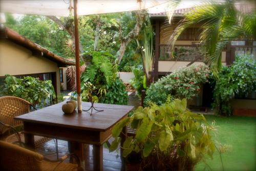 a patio with a table with plants and an umbrella at Villa Balthazar in Búzios