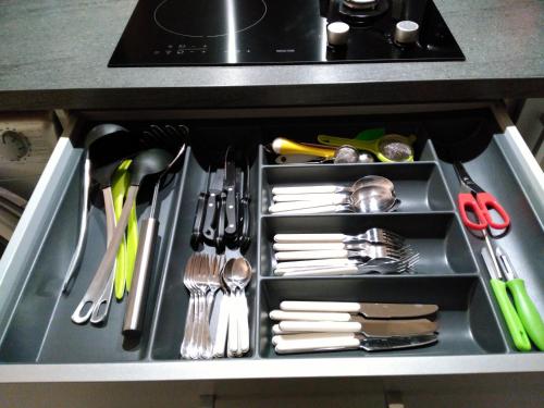 un tiroir rempli d'ustensiles de cuisine dans une cuisine dans l'établissement Bel et spacieux appartement de 84 m² avec parking très proche du Métro Garibaldi, à Lyon