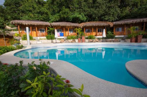 a swimming pool in front of a resort at Magic Oceans Dive Resort in Anda