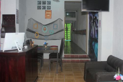 un salon avec une table et des chaises ainsi qu'un couloir dans l'établissement Hostel Áabilo'ob, à Progreso