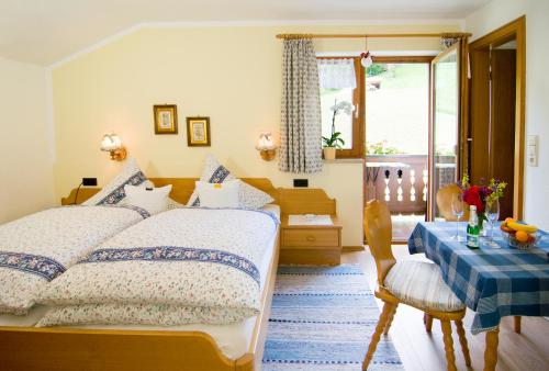 a bedroom with two beds and a table and a window at Haus Christl Reit im Winkl, Kostenloser Parkplatz, Spülmaschine, 5 Minuten zum Ortszentrum, ruhige Lage, Wlan in Reit im Winkl