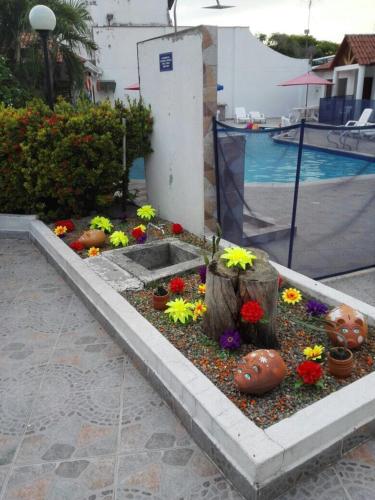 a garden with flowers and a tree stump at Hotel Villa Ricaurte in Girardot