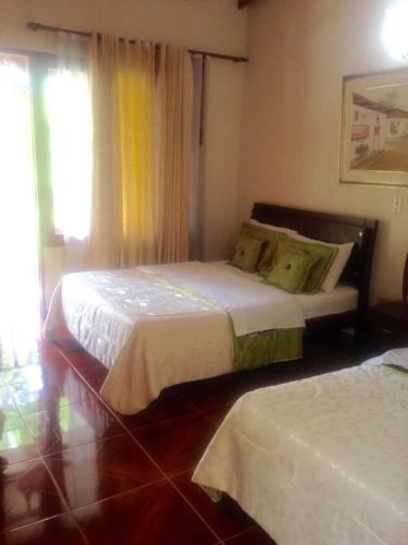 a bedroom with two beds and a window at Hosteria Campestre San Fermin in Ráquira